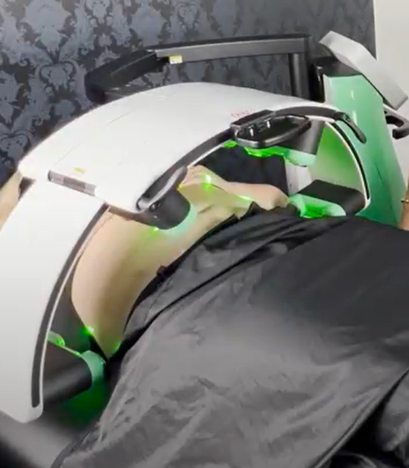 Laser Weight Loss session at Hayden Idaho Med Spa with person on treatment table, green light device targeting body for fat reduction. at North Idaho Med Spa in Hayden